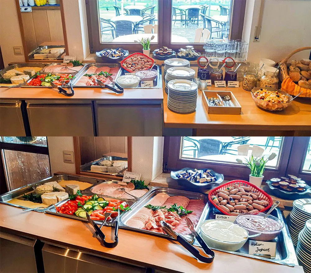 Frühstücksbuffet mit verschiedenen Speisen: Auf der linken Seite sind Aufschnitt, Käse, Gemüse und Joghurt in Schalen und Platten angeordnet. Rechts sind Brötchen, Müsli und Obst in Körben und Gläsern.